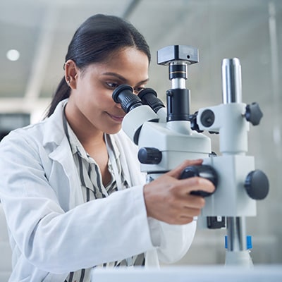 Scientist looking through microscope